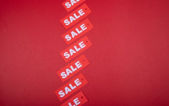 Red sale tags aligned diagonally on a red background, perfect for retail promotions.